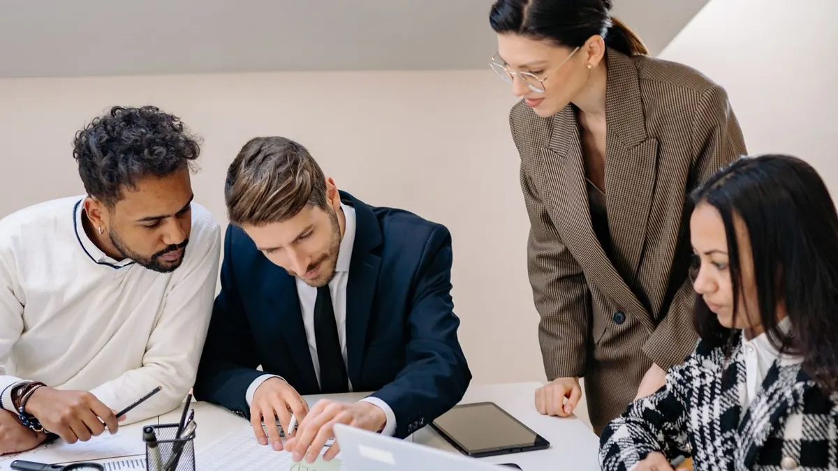 Equipo de negocios generando ideas en un espacio de trabajo, utilizando un portátil para planificar.