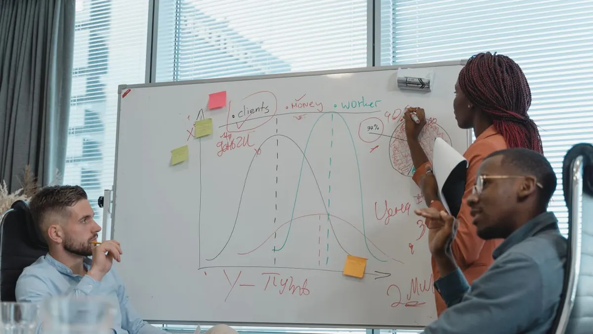 Un equipo diverso en una oficina moderna colaborando en una estrategia empresarial, utilizando una pizarra para generar