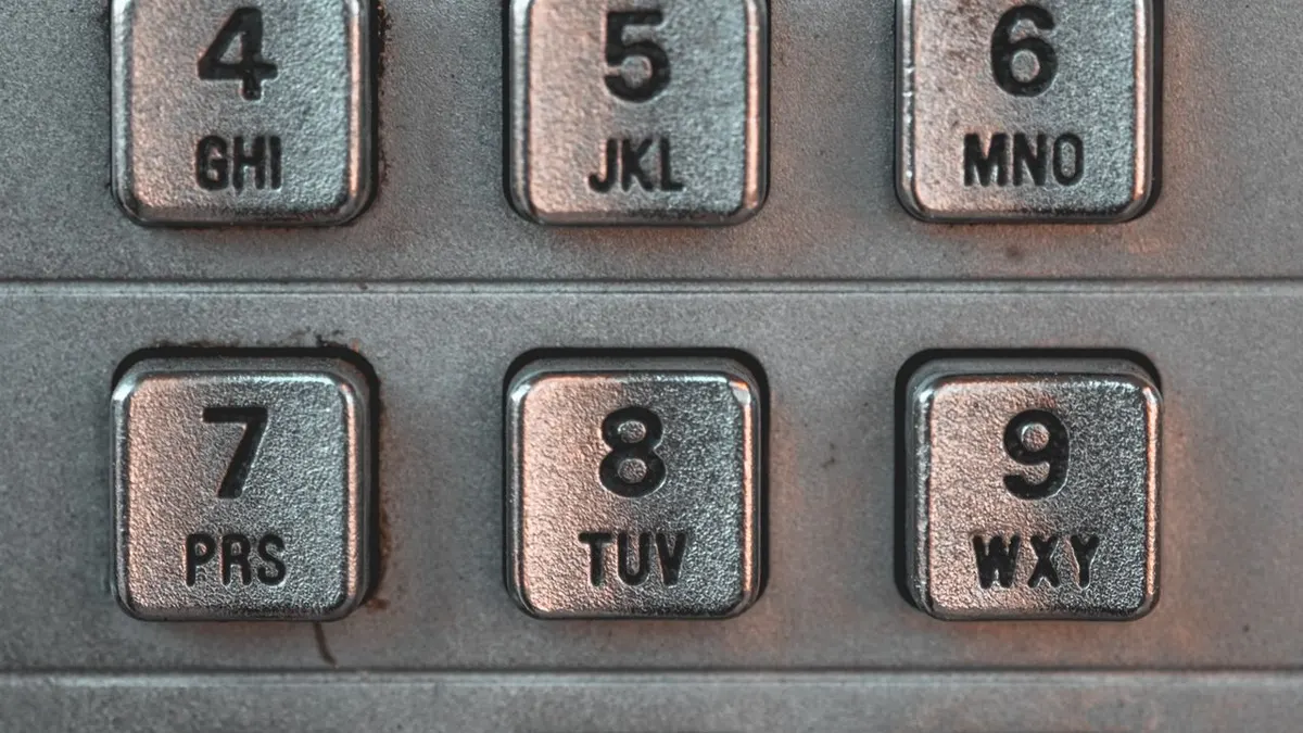 Vista detallada del teclado metálico antiguo de una cabina telefónica pública en Montreal, que muestra tecnología clásica.