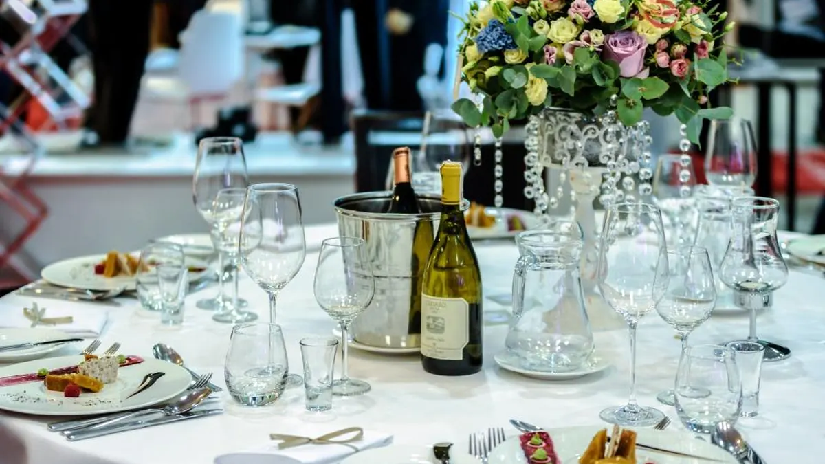 Mesa de banquete preparada con copas y flores para un evento