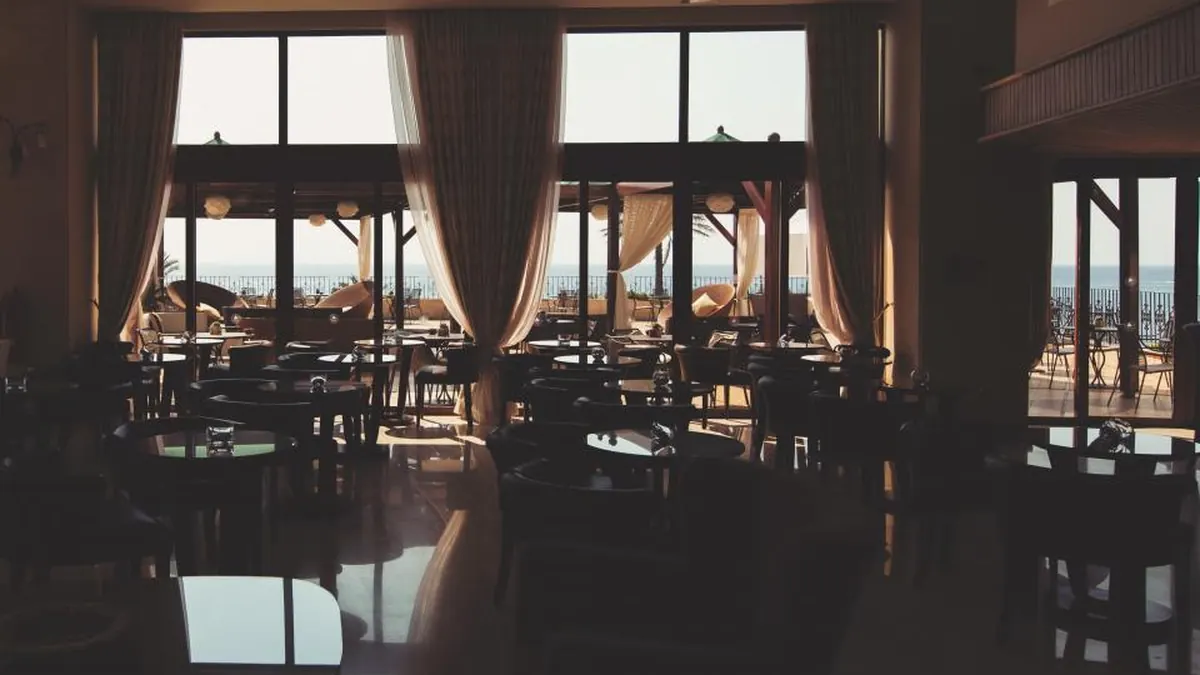 Sala de restaurante con las mesas vacías junto a las ventanas
