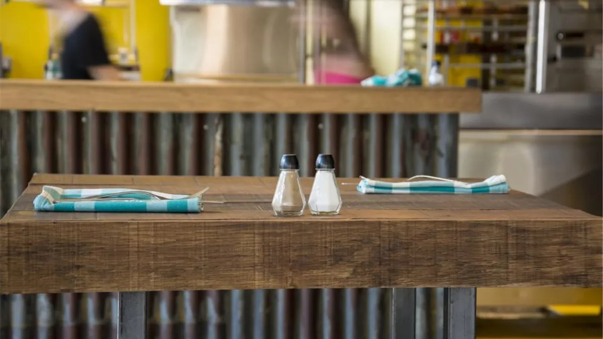Mesa de madera con sal y pimienta en un restaurante