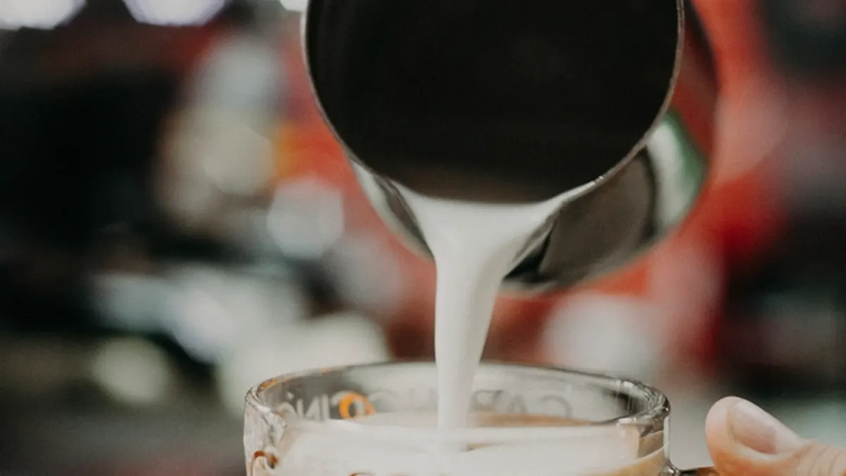 Barista sirviendo un café con leche