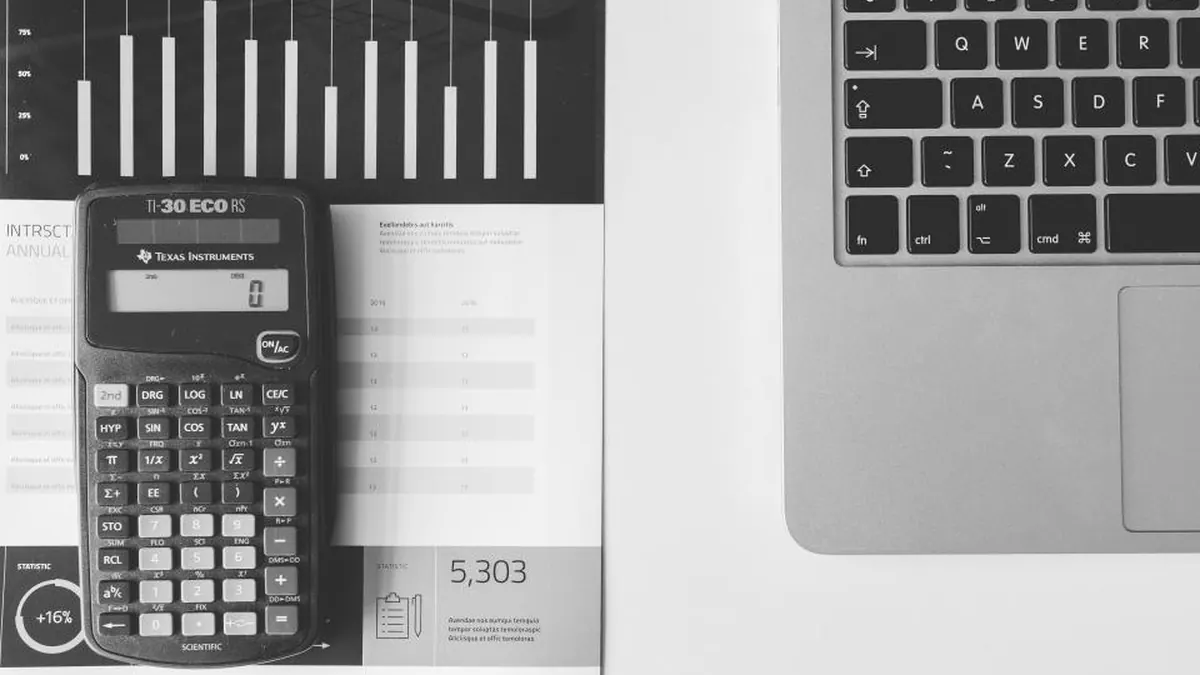 Calculadora, portátil y gráficos de barras impresos