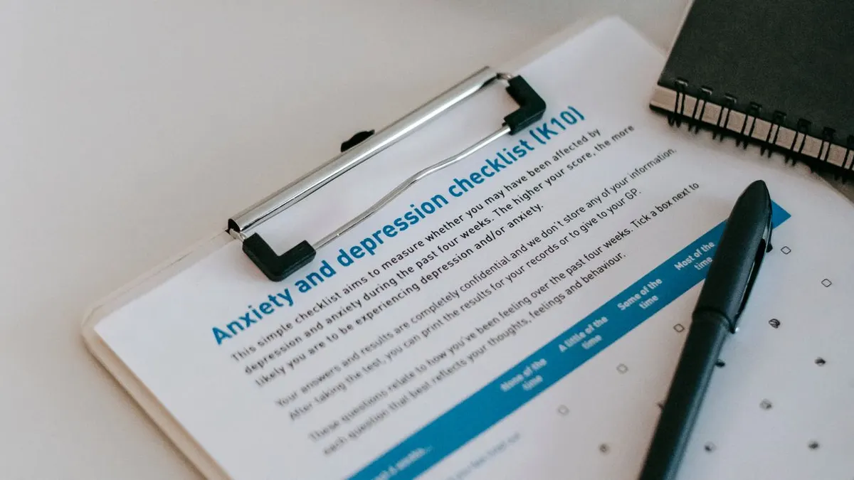 Vista superior de la lista de verificación de ansiedad y depresión en el portapapeles con café y bolígrafo.