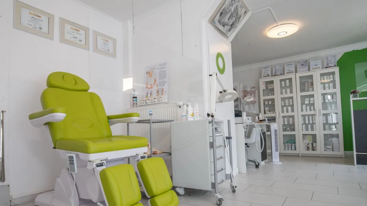 Un interior de clínica médica limpio y moderno que presenta una vibrante silla de tratamiento verde y equipos organizados.