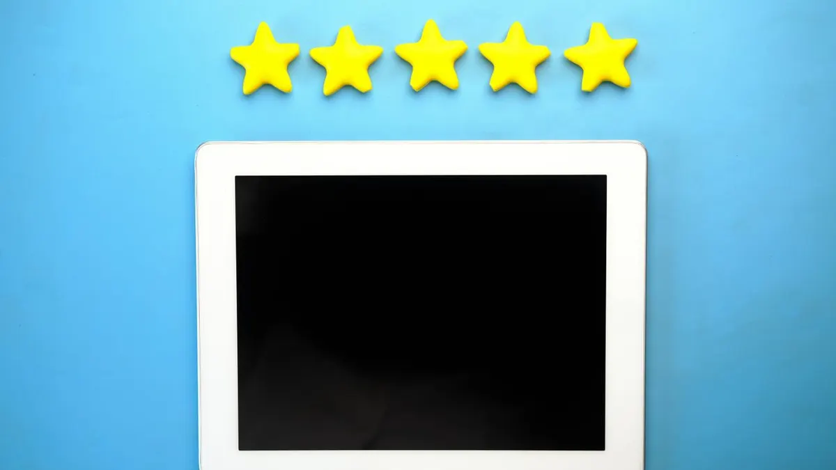 Tablet con cinco estrellas amarillas sobre un fondo azul, ideal para calificar conceptos.