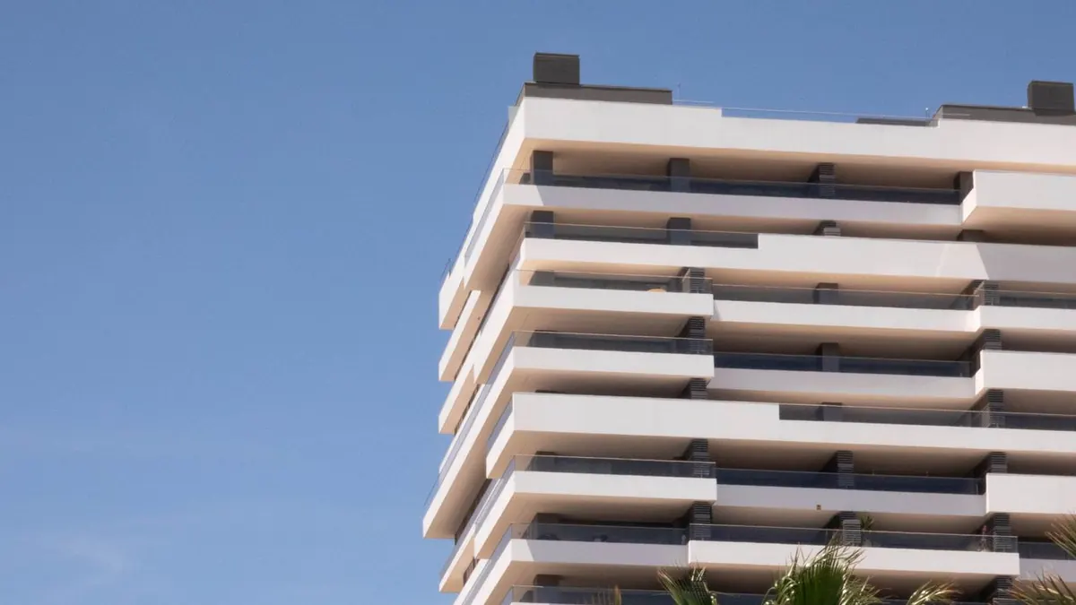 Edificio contemporáneo con palmeras contra un cielo despejado en Málaga, España.