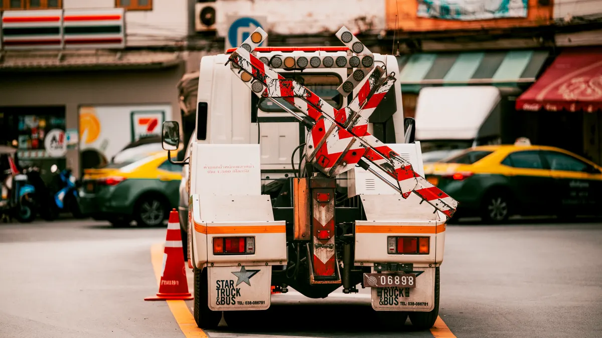 Vehículo utilitario con barreras de tráfico en una calle concurrida de Bangkok, Tailandia.