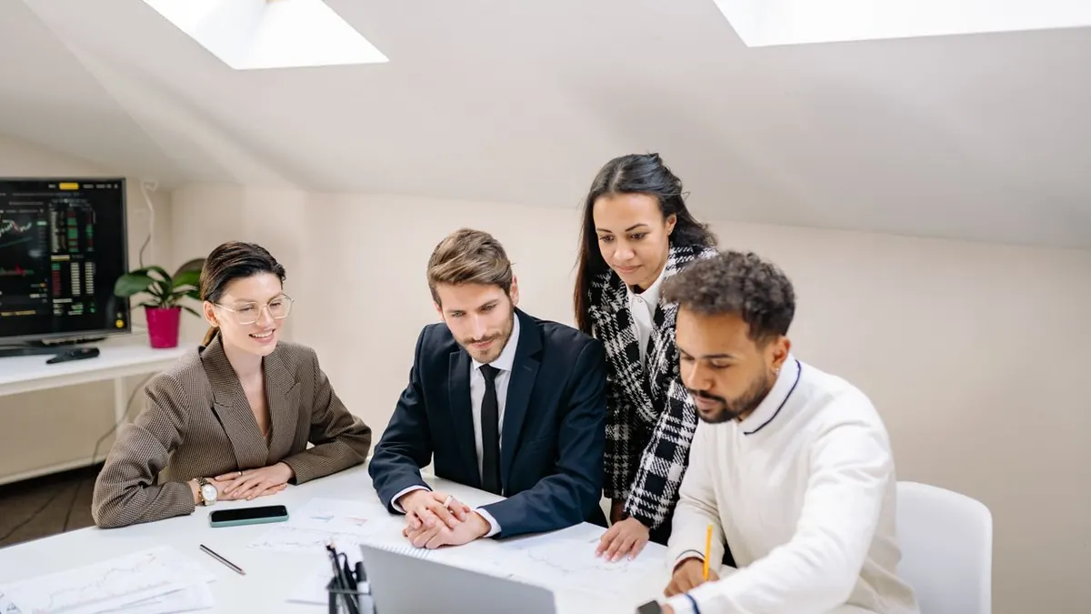Un equipo diverso de profesionales colaborando y discutiendo trabajo en un entorno de oficina moderno.