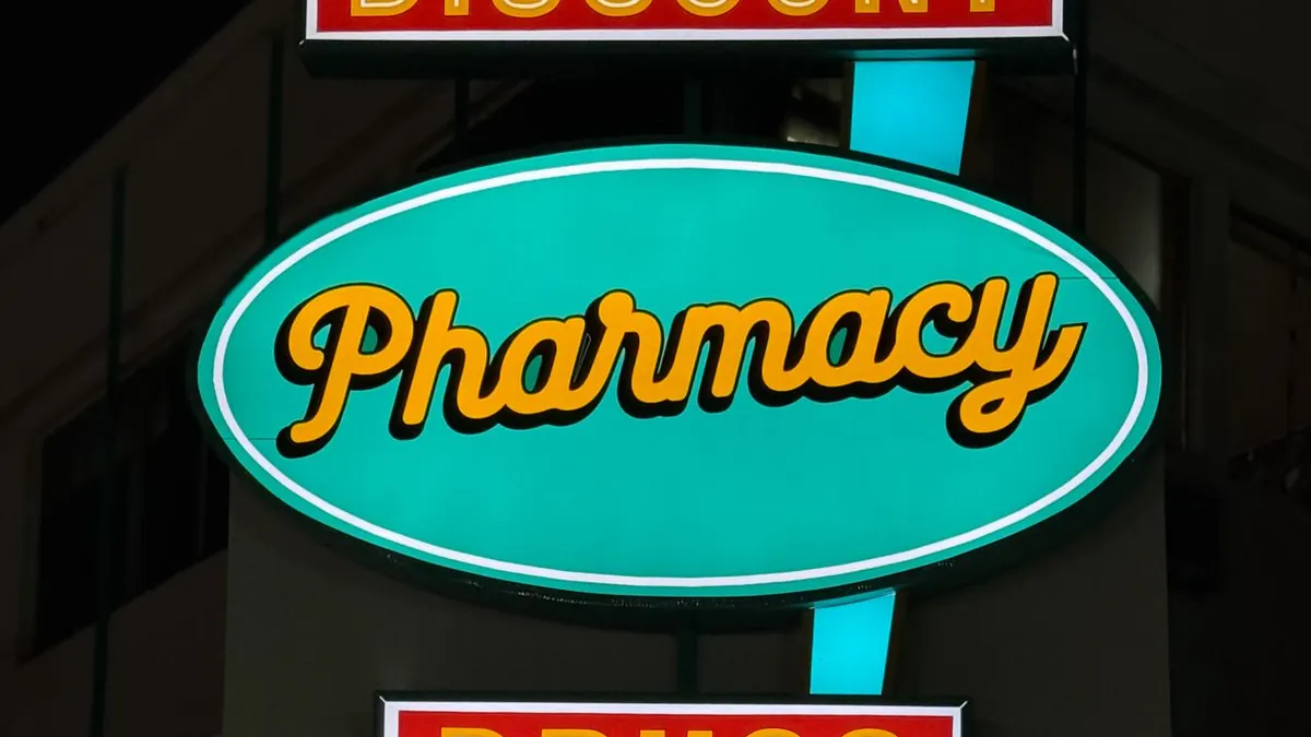 Un letrero de farmacia de neón vintage que brilla intensamente durante la noche en Tijuana, México.