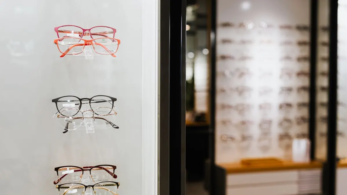 Variedad de gafas exhibidas en un display de pared en una tienda óptica.