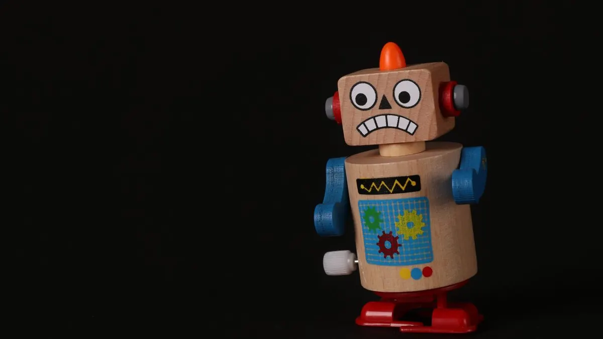 Un vibrante robot de juguete de madera se encuentra sobre una superficie oscura, mostrando colores vivos y un diseño