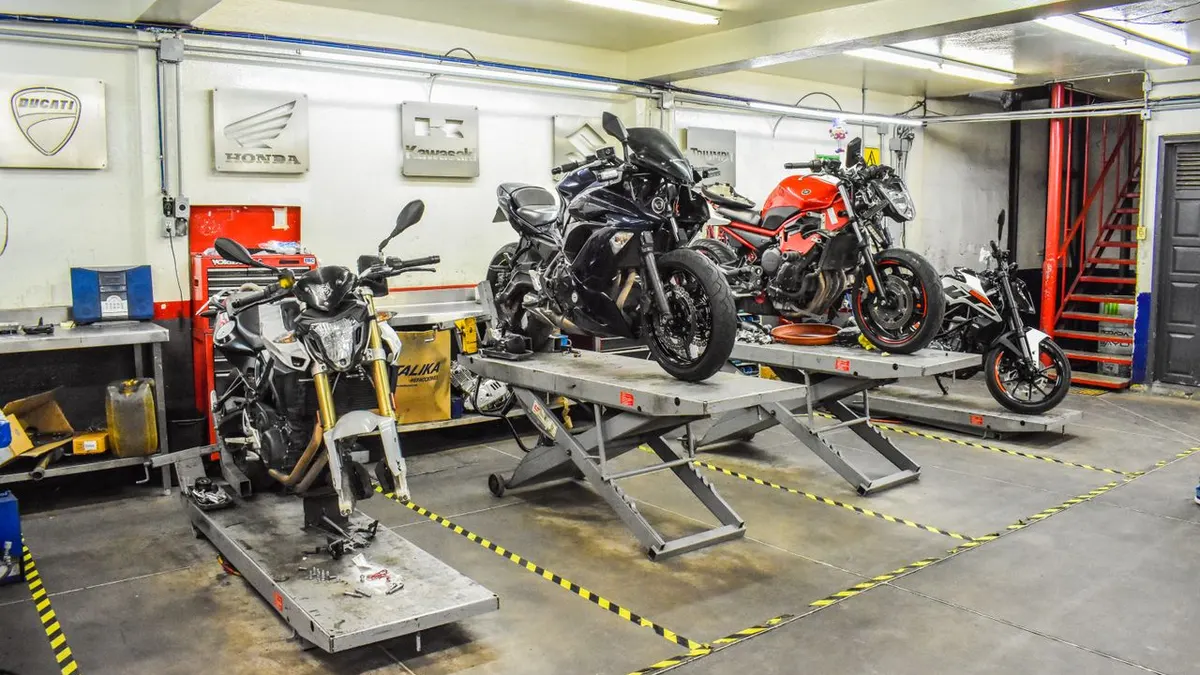 Taller de reparación de motocicletas con motos Ducati, Honda y Kawasaki en soportes.