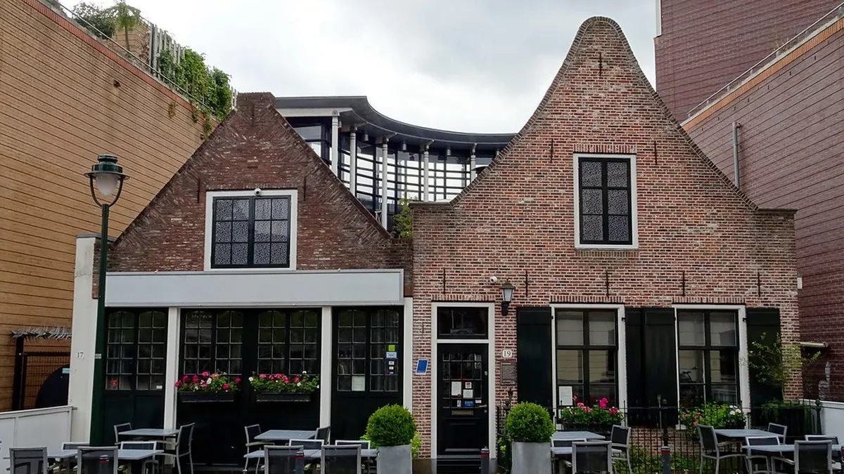 Fachada de un restaurante con mesas en la terraza