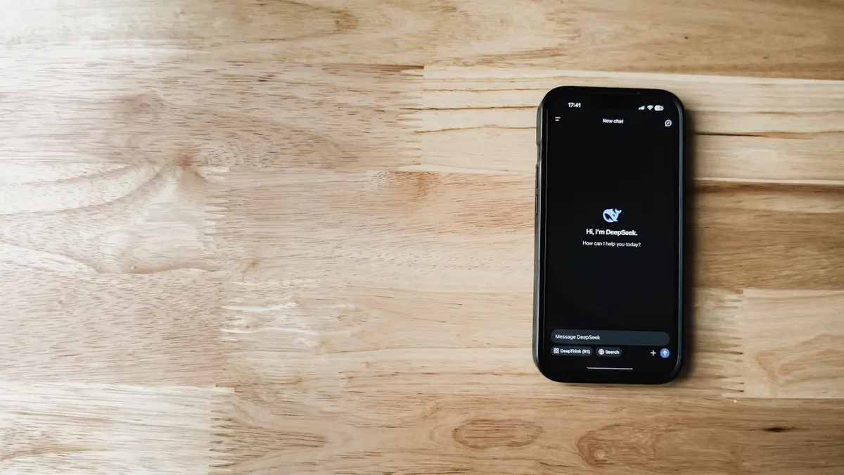 Teléfono móvil que muestra la interfaz de chatbot de IA sobre una mesa de madera
